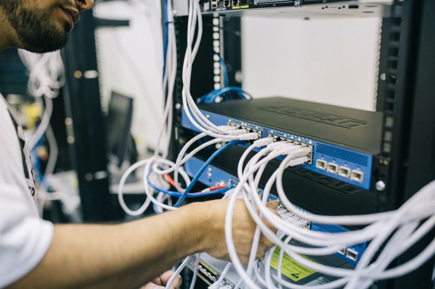 It tekniker, der sætter netværkskabler i et serverrack